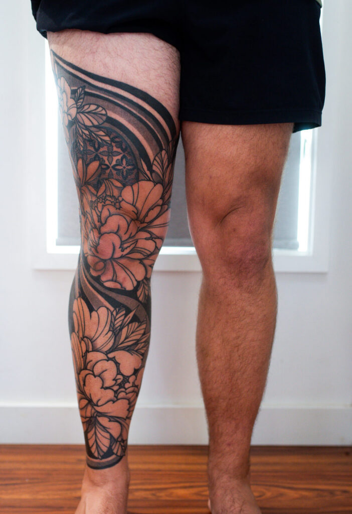 Kuhn's Full Floral and Black Work Leg, front view, floral and black work tattoo by Simon Halpern, Kāneʻohe, Oahu