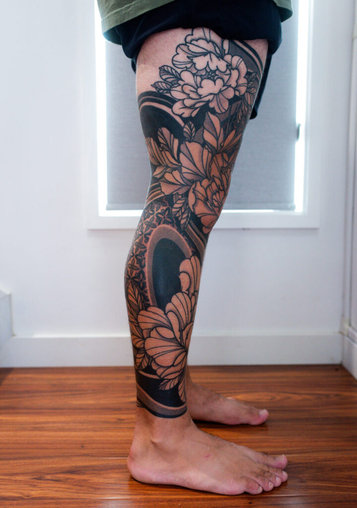 Kuhn's Full Floral and Black Work Leg, side view, floral and black work tattoo by Simon Halpern, Kāneʻohe, Oahu